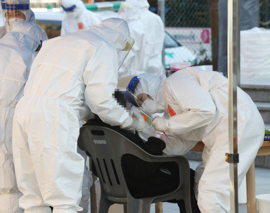 12일 오후 울산시 울주군 한 초등학교에 설치된 선별진료소에서 한 학생이 코로나19 검사를 받고 있다. 이날 이 학교 학생 1명이 코로나19 확진 판정을 받아 학생과 교직원 등 900여명을 대상으로 검사가 이뤄졌다.   연합뉴스